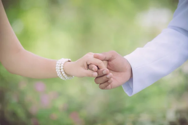 Любовь - романтическая пара, держащаяся за руки в саду для иллюзиониста — стоковое фото