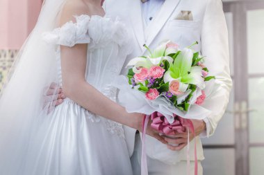 Bir buket çiçek ile bir düğün günün kutlu olsun tutan Çift 