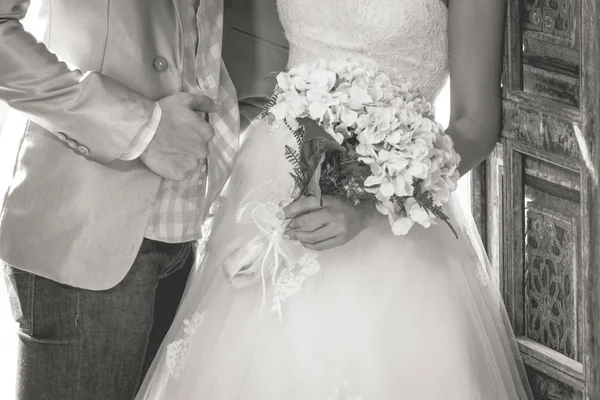 Pareja sosteniendo un ramo de flores con un feliz día de la boda —  Fotos de Stock