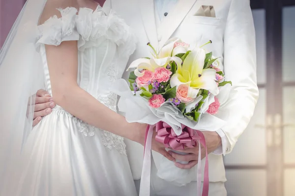 Casal segurando um buquê de flores com um feliz dia de casamento — Fotografia de Stock