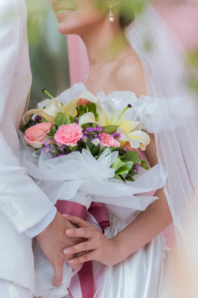 Couple holding a bouquet of flowers with a happy wedding day — Stock Photo, Image