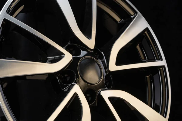 car cast aluminum alloy wheels, black silver with polished front, very beautiful and modern, fashion. Close-up on dark background, elements, spokes.