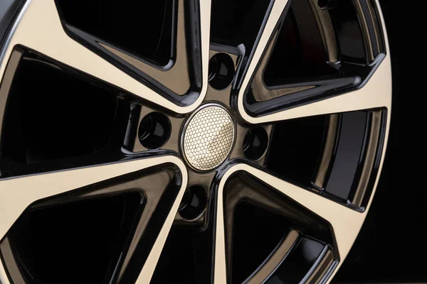 cast aluminum disc alloy wheel modern, close-up on black background, spokes and rim