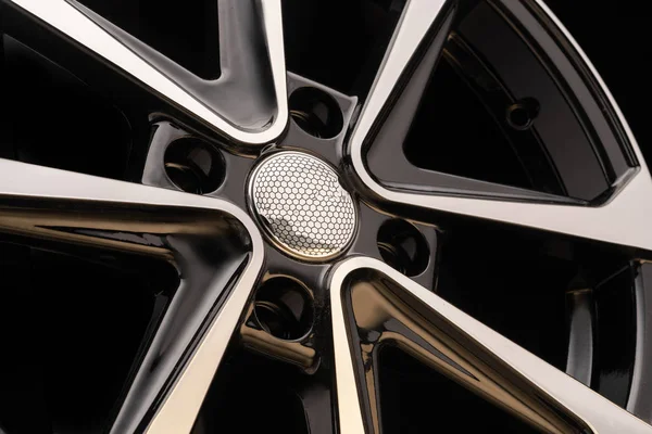 cast aluminum disc alloy wheel modern, close-up on black background, spokes and rim