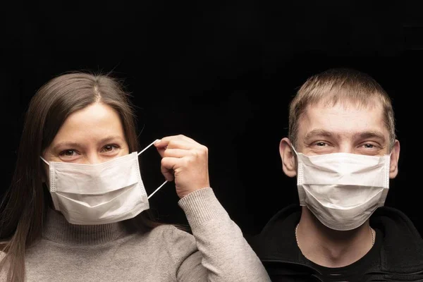 and funny people, a man and a woman in protective medical antimicrobial and anti- bacterial masks from coronavius covid 2019. they smile and laugh
