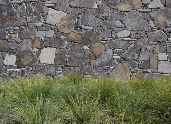 Taş duvarlara karşı çimenli bir bahçe Stok Fotoğraf