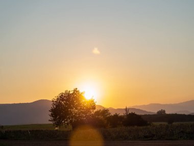 Dağlarla, çiçeklerle, otlarla, günbatımıyla geniş bir alan.