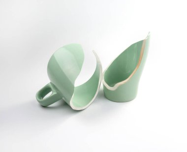 Beyaz arka planda kırık kahve fincanı, kırık bardak parçaları, kırık ilişki ve ayrılık konsepti.