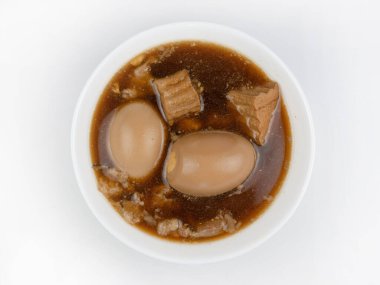 Beyaz arkaplanda yumurta, Tayland yemeği tarafından kahverengi soslu yumurta, tatlı kahverengi soslu domuz eti (Khai Palo).