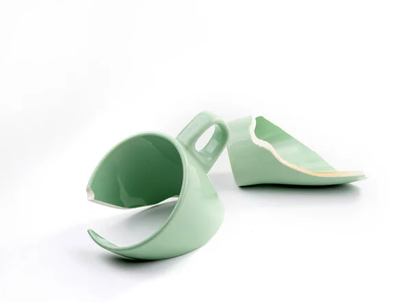 Beyaz arka planda kırık kahve fincanı, kırık bardak parçaları, kırık ilişki ve ayrılık konsepti.