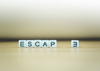 ESCAPE sözcüğü ahşap zemin üzerinde beyaz zemin üzerine küp ile yazılmış, harf blokları ESCAPE sözcüklerine, metin veya diğer resim veya tasarım eklemek için düzenlenir