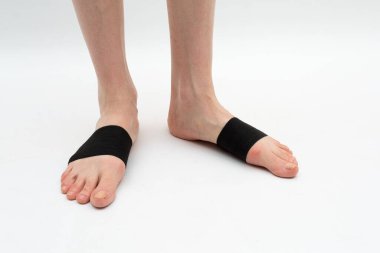 cuff-tie for the anterior part of the foot with a metatarsal roller on the legs of a woman to correct the big toe for hallux valgus, 2 legs, isolated close-up, white background clipart