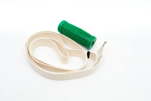 massage roller for effective massage of acupuncture points of the feet and yoga belt on a white background. the concept of a healthy body