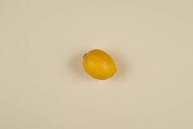 Bir limon, bağışıklık sisteminin meyvesi, sarı arka planda virüsle savaşıyor.