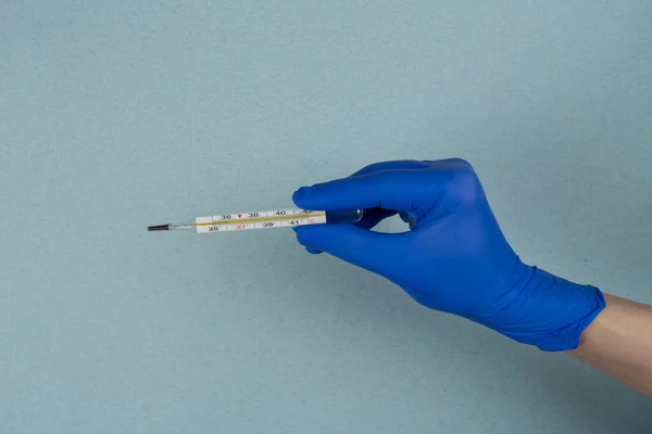 Termometr Rękach Lekarza Rękawiczkach Odizolowanych Niebieskim Tle Kwarantanna Dla Coronavirus — Zdjęcie stockowe