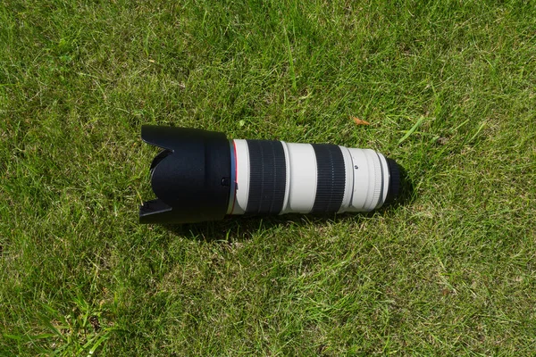 緑の草の上のプロ仕様のカメラレンズ — ストック写真