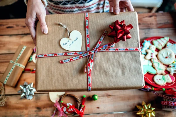 Mãos de mulher entregando um presente de Natal . — Fotografia de Stock