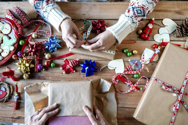 Händerna på två personer inslagning julklappar — Stockfoto