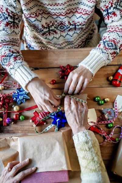 Händerna på två personer inslagning julklappar Royaltyfria Stockbilder