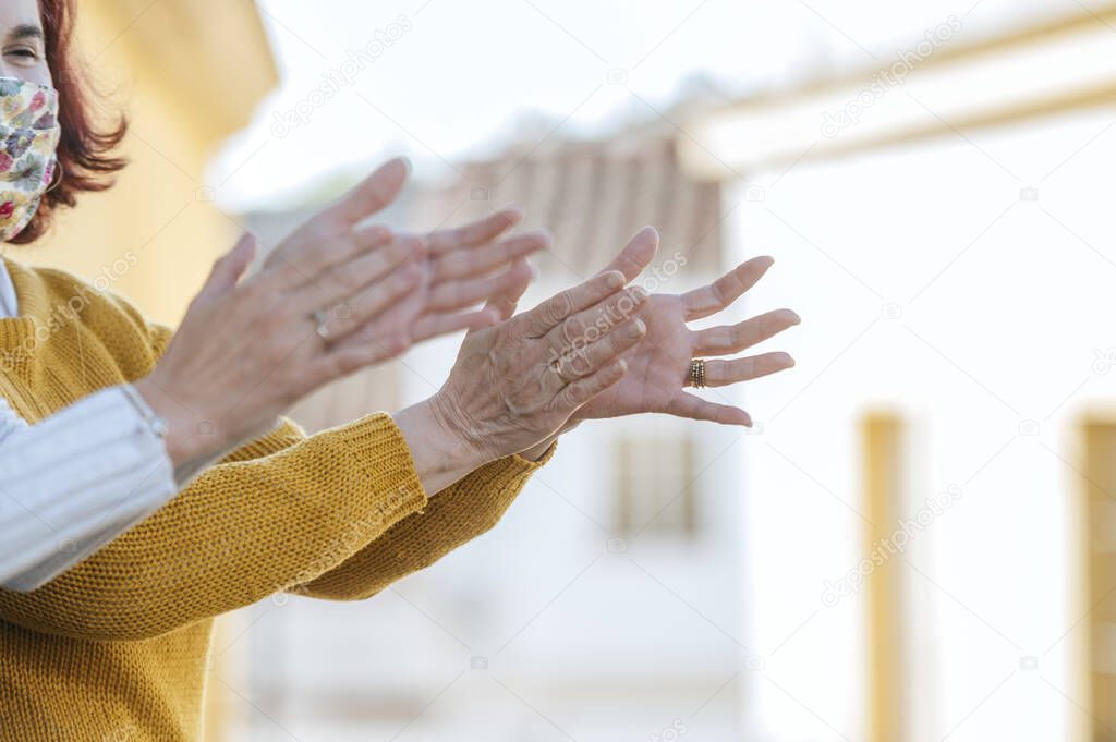 Two women clapping on the balcony