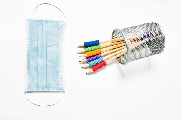 白い背景にペンと抗ウイルスマスクの色鉛筆 — ストック写真