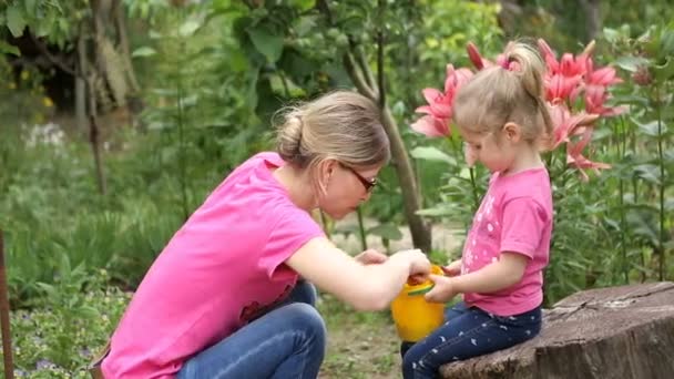 Мать и маленькая дочь едят тутовую ягоду — стоковое видео