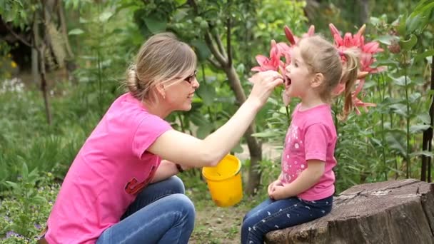 Mother and little daughter eat berries mulberry — Stock Video