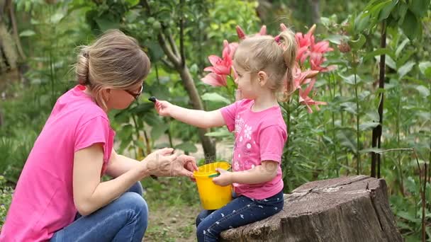 Mother and little daughter eat berries mulberry — Stock Video