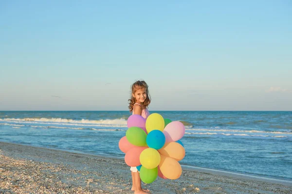 Balonlar ile sahilde mutlu küçük kız. — Stok fotoğraf