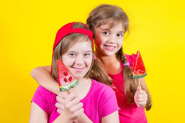 Mädchen Down-Syndrom und kleines Mädchen mit großem Lutscher Stockfoto