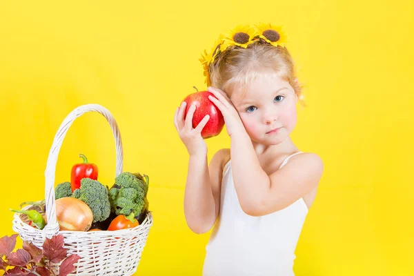 Beautiful little happy girl with basket of vegetables and fruits — Stock Photo, Image