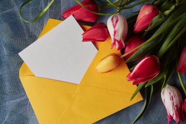 Soyut arkaplanda kırmızı, sarı ve renkli laleler ve zarf