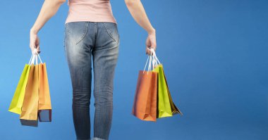 alışveriş torbaları üzerinde mavi arka plan ile kadın