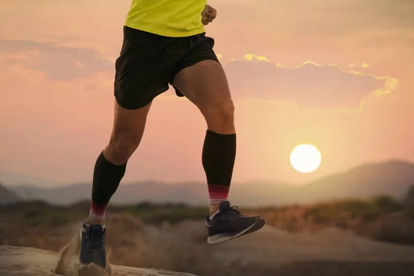 해질 녘에 시골 트랙을 달리는 달리기 선수의 다리 와발을 클로즈업 한 모습 — 스톡 사진