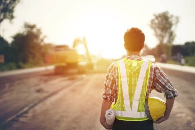 İnşaat alanının planlarını elinde tutan mühendis.