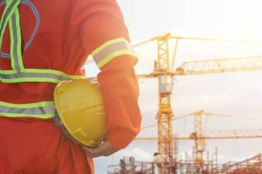 İnşaat alanında miğfer tutan mühendis.