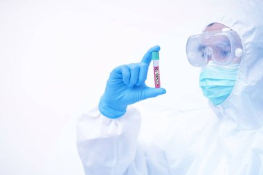 COVID-19, Coronavirus ve kişisel koruyucu ekipman ya da PPE 'de çalışan bir doktor. Test tüpü tutuluyor