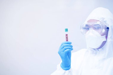 COVID-19, Coronavirus ve kişisel koruyucu ekipman ya da PPE 'de çalışan bir doktor. Test tüpü tutuluyor