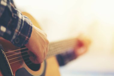 Akustik gitar çalan bir adam.