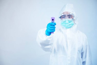 Kişisel koruma ekipmanı ya da PPE 'de çalışan bir doktor. dijital termometre, Coronavirus covid-19 salgın konsepti