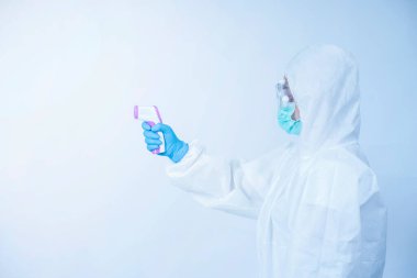 Kişisel koruma ekipmanı ya da PPE 'de çalışan bir doktor. dijital termometre, Coronavirus covid-19 salgın konsepti