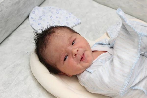 Egy kis újszülött fiú 7 napig volt kórházban, a kamerába nézett. Haj sötét bőr sötét. — Stock Fotó