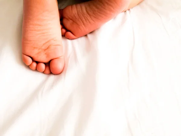 Kleine baby met schattige voeten op bed blad, boven de weergave. Ruimte voor tekst — Stockfoto
