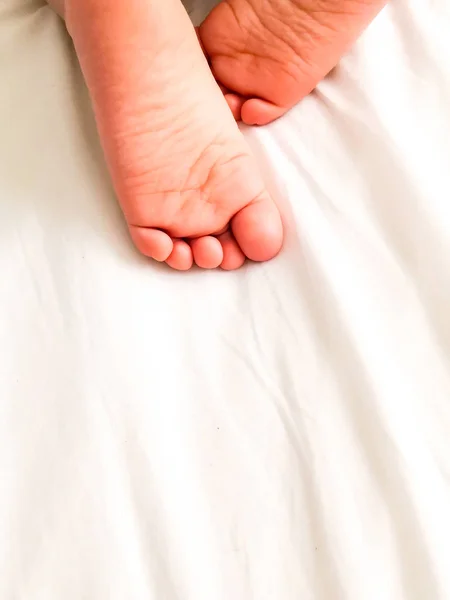 Little baby with cute feet on bed sheet, above view. Space for text — Stock Photo, Image