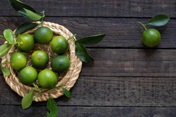 Grön Kumquat frukten på trä bakgrund — Stockfoto
