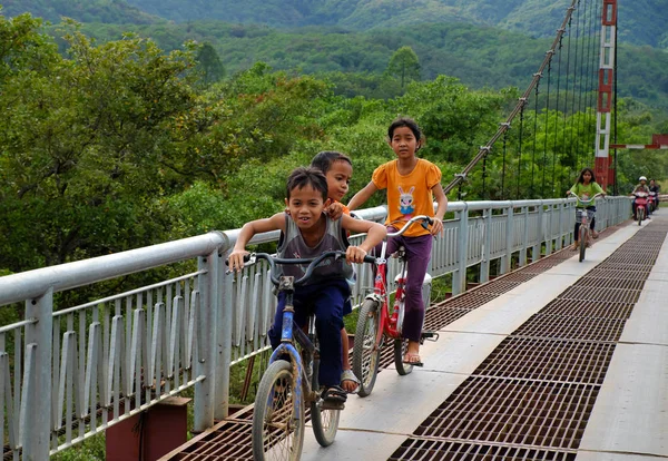 Vietnamesische Kinder fahren Fahrrad auf Hängebrücke — Stockfoto