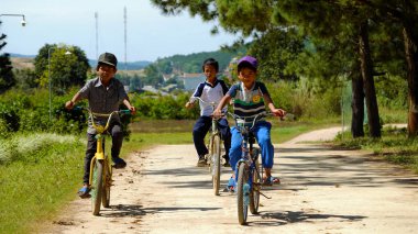 Vietnamlı çocuklar ülke yolunda bisiklete biniyor