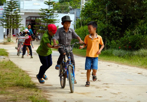 Vietnamesische Kinder fahren Fahrrad auf Landstraße — Stockfoto