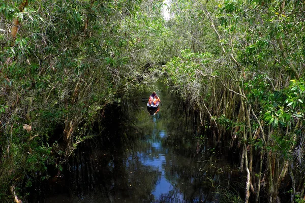 Mujer remando bote de remo a través del bosque — Foto de Stock