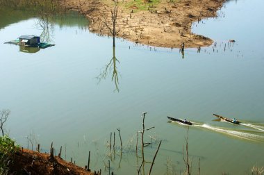 İki adam Motorlu tekne tekne yarışı, tekne hızlı ilerlemeye yapmak dalga paterni yüzey Su Nam ka Gölü, Dak lak, Viet Nam